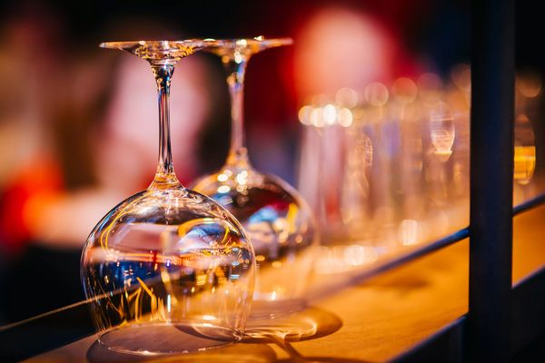 Two clean shiny polished wine glasses on bar restaurant counter top background
