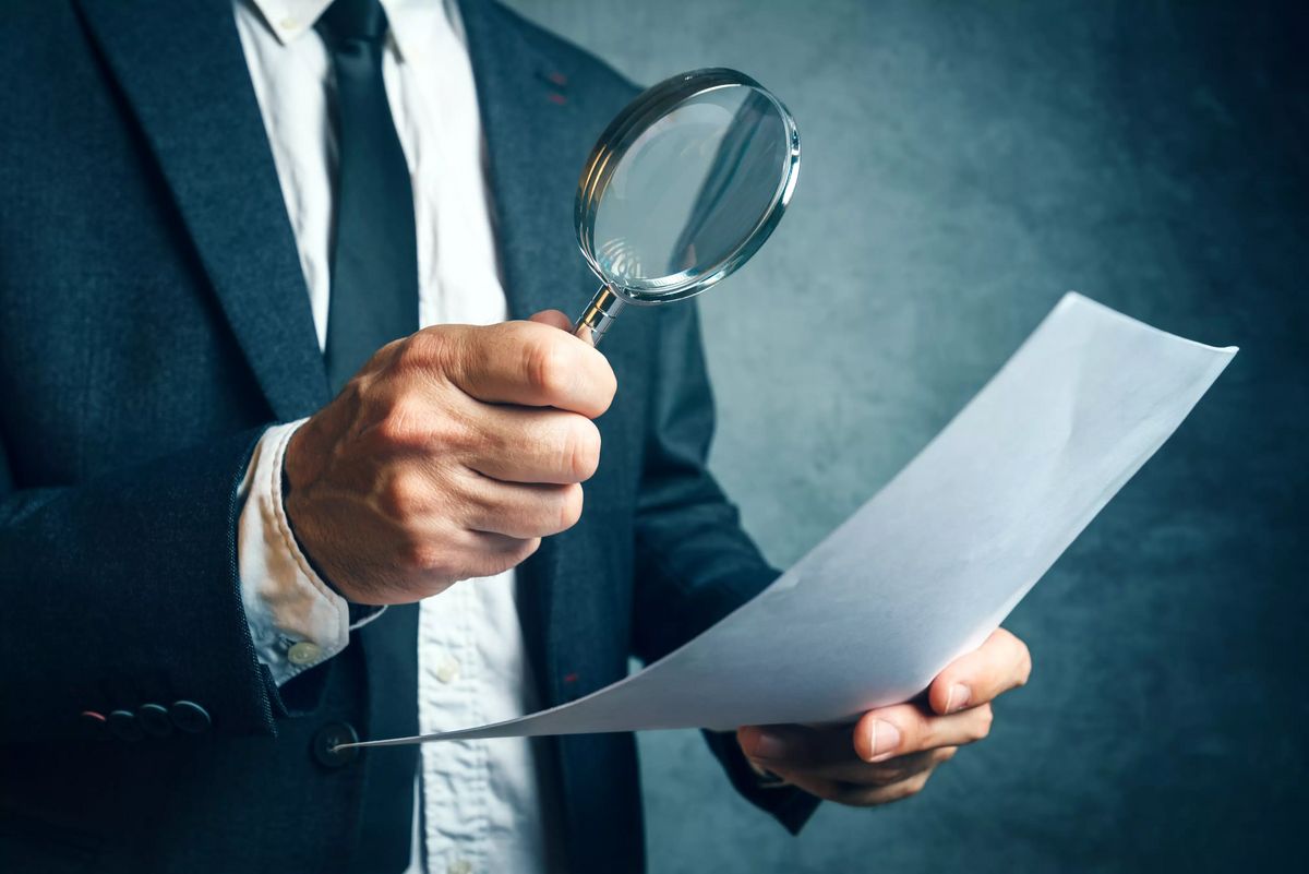 Tax inspector investigating financial documents through magnifyi