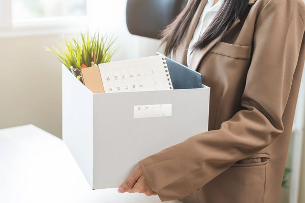 Unemployed, quite job. Desperate asian young businesswoman resigning from company, hand holding cardboard, packing belongings, stuff into box, layoff or changing work. Resignation, employment concept.