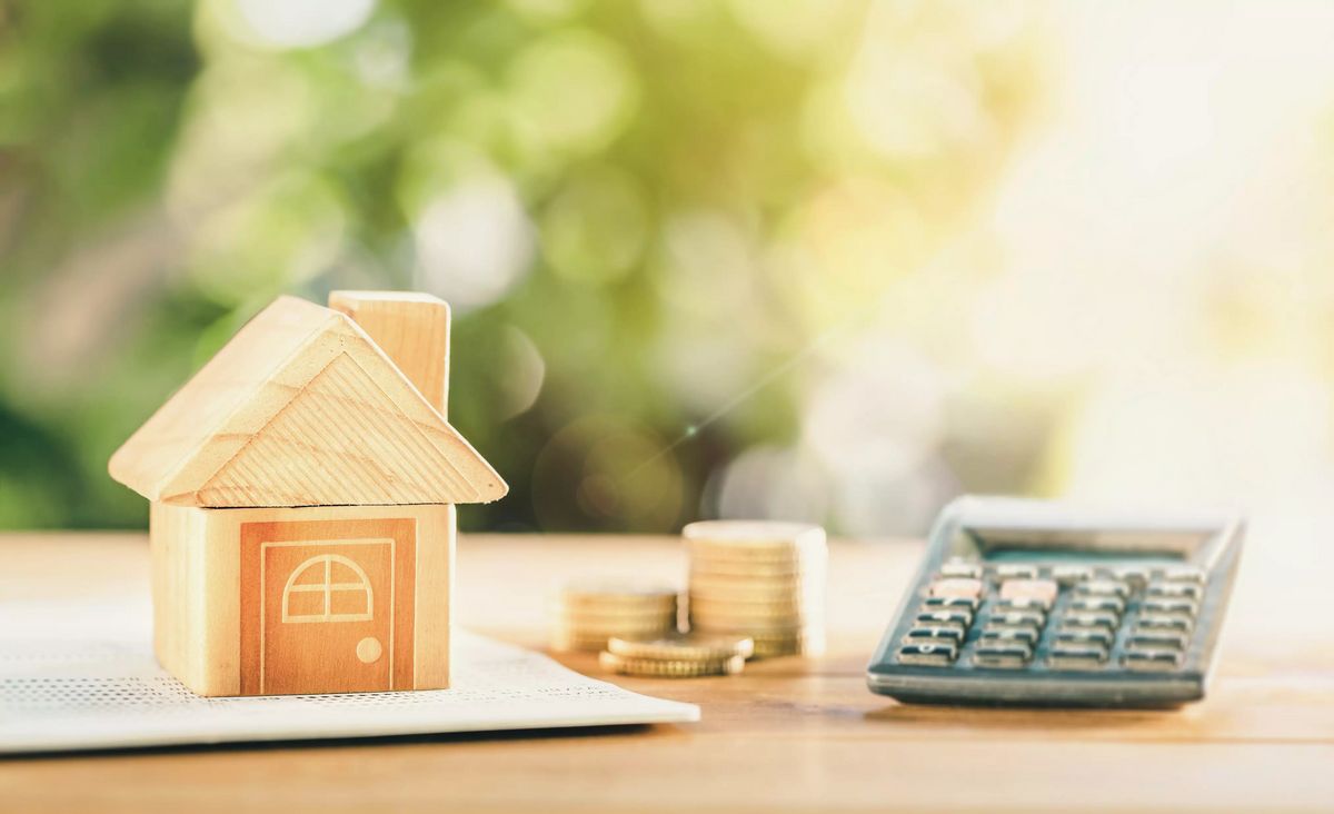 close up house's model on banking account book with calculator, coin and pencil on table for planning of home loan mortgage refinance or retention interest rates.