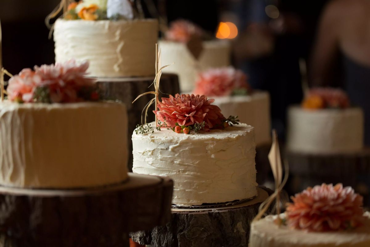 Display of multiple wedding cakes with dahlias