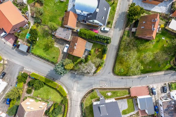 Single house in a new building settlement with houses and properties with gardens, aerial photo