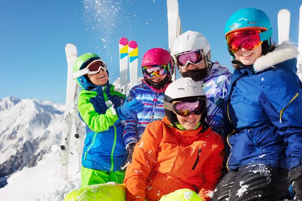 Group of ski school children have fun with snow on the mountain top