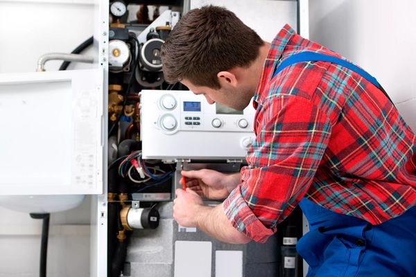 Technician servicing heating boiler