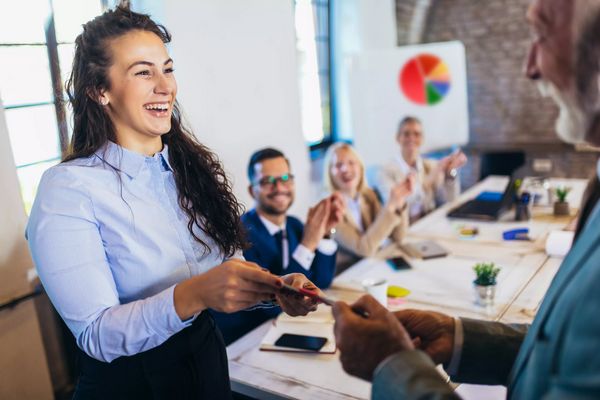 Businesswoman receiving award from businessman in front of busin
